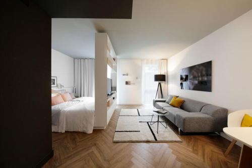 uma sala de estar com uma cama e um sofá em SMARTments business München Parkstadt Schwabing em Munique
