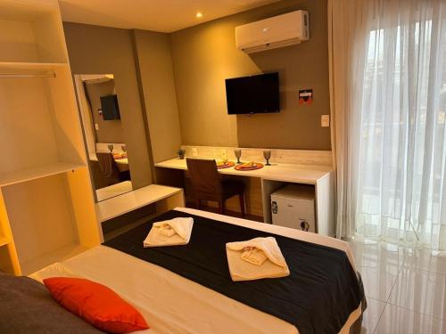 um quarto de hotel com uma cama e uma secretária em Flat 218 no bairro da Passagem em Cabo Frio em Cabo Frio