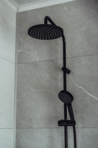 a shower with a black shower seat in a shower at Arrivée - 5-Star Luxury Sports-Inspired Holiday House in Merelbeke