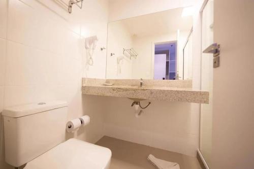 Flat 218 no bairro da Passagem em Cabo Frio في كابو فريو: حمام أبيض مع حوض ومرحاض