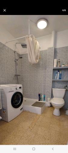 une salle de bain avec machine à laver et toilettes dans l'établissement Beau studio mer, à Saint-Cyprien
