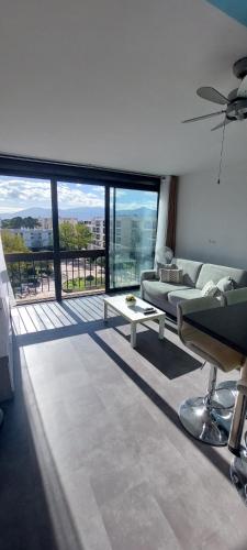 un salon avec un canapé et une grande fenêtre dans l'établissement Beau studio mer, à Saint-Cyprien