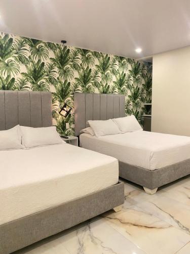 2 camas en un dormitorio con papel pintado en WH HOTEL en San Andrés