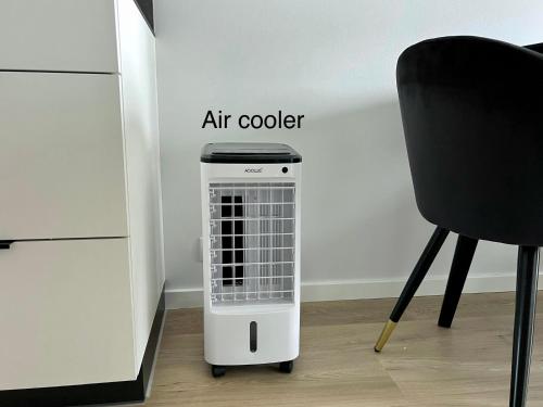 an air cooler sitting on the floor next to a chair at 15 korruse premium katusekorter in Tallinn