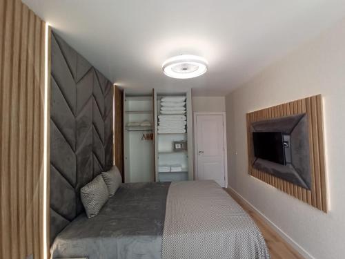 a bedroom with a bed and a flat screen tv at Tranquilo Escapes in Sunny Beach