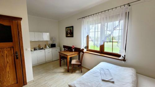 a bedroom with a bed and a table and a window at Gościniec Krys in Żnin