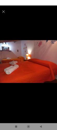 a bedroom with a red bed with two towels on it at Villa paradiso in Castellammare del Golfo