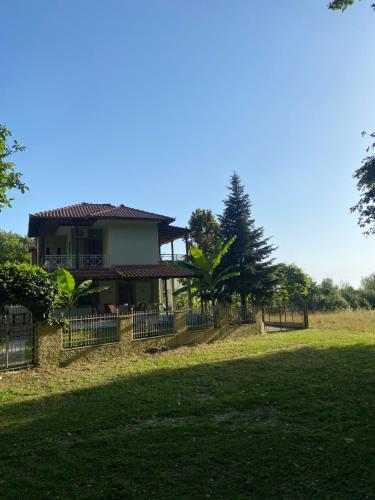 a house with a fence in front of a field at Villa-Litsa in Leptokaria