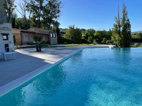 duży basen z niebieską wodą na dziedzińcu w obiekcie Casa Ripa Guest House w mieście Cupramontana