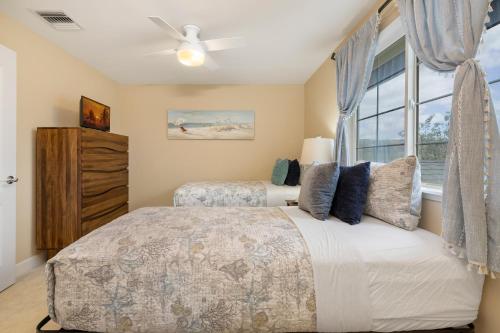 a bedroom with two beds and a window at Hillside Villas 1498-3 in Kapolei