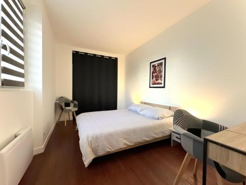 une petite chambre avec un lit et une fenêtre dans l'établissement Le Charmant Grenoble, à Grenoble