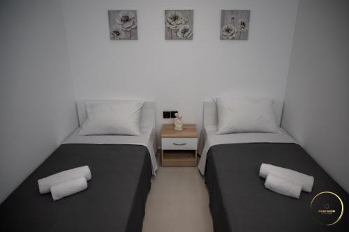 a room with two beds and a night stand at Sunset Shores Mola Kaliva in Mola Kalyva