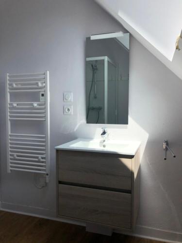 une salle de bain avec un lavabo et un miroir dans l'établissement Ty Albertine - Maison de campagne rénovée proche de la mer, à Plonévez-Porzay