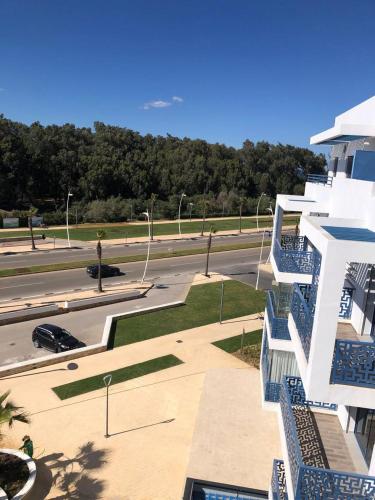 a building with blue stairs next to a parking lot at Costa Mar, Playa 5 in Martil
