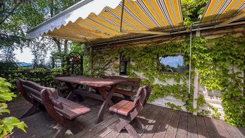 a wooden table and chairs under an umbrella on a patio at Noclegi Bajama in Siepraw