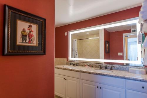 a bathroom with two sinks and a large mirror at Howard Johnson by Wyndham Anaheim Hotel & Water Playground in Anaheim