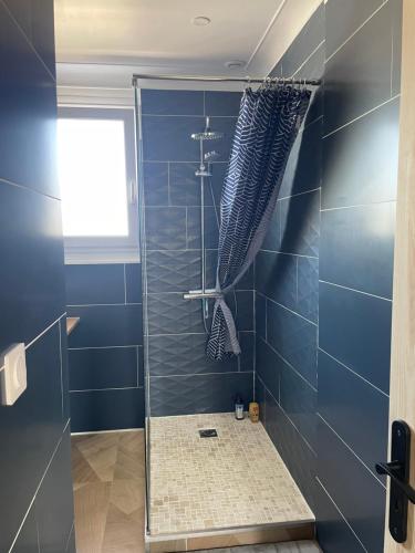 a bathroom with a shower with blue tiles at La Villa Sénéchal in Guérande