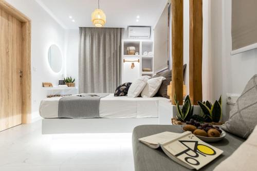 a white bedroom with a bed and a table at Saronada Studio in Kinídharos