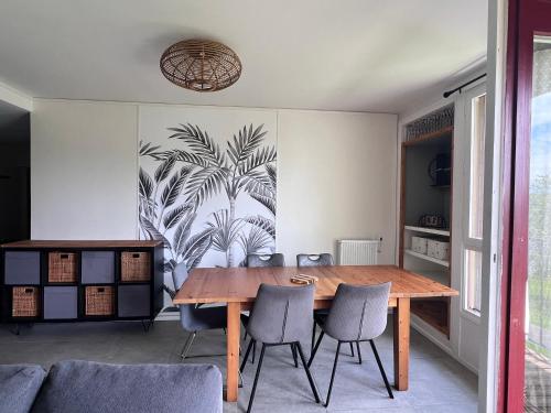 une salle à manger avec une table et des chaises en bois dans l'établissement Appartement grande capacité Bayonne, à Bayonne