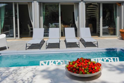a bowl of strawberries sitting next to a pool at Villa Paolina in Sulzano