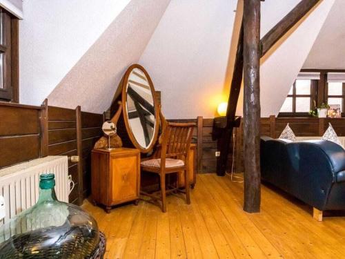 ein Wohnzimmer mit einem Bett und einem Spiegel in der Unterkunft Attractive apartment in Katzweiler in Brakel