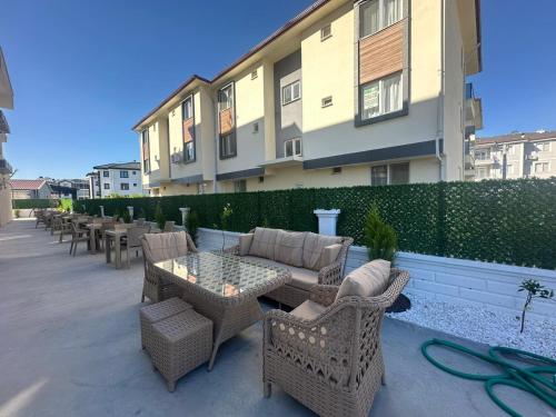 a patio with wicker chairs and tables and a building at The Brothers Suite Dalaman in Dalaman