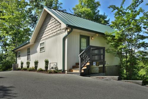 a white house with a porch and a driveway at Pine Needles by Eden Crest in Pigeon Forge