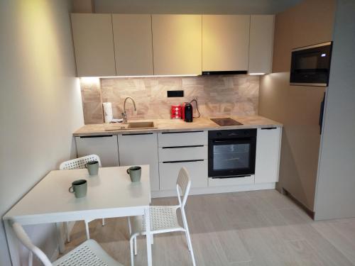 a small kitchen with a white table and chairs at New Townhouse Apartment in Šamorín