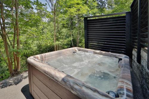 a jacuzzi tub sitting in a yard with trees at Pine Needles by Eden Crest in Pigeon Forge
