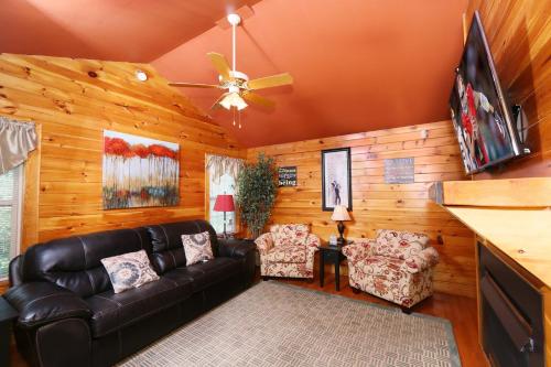a living room with a couch and a flat screen tv at Pine Needles by Eden Crest in Pigeon Forge