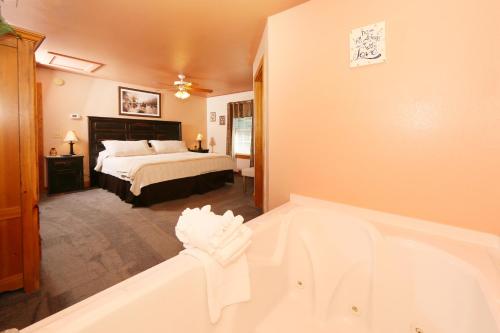 a bathroom with a tub and a bedroom with a bed at Pine Needles by Eden Crest in Pigeon Forge