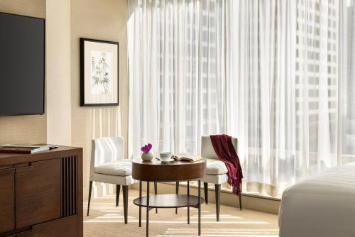 a hotel room with a bed and a table and chairs at Hyatt Vancouver Downtown Alberni in Vancouver