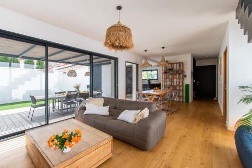 un salon avec un canapé et une table dans l'établissement LA CONTEMPORAINE au calme avec sa piscine, wifi fibre, 8 personnes, à La Grande Motte