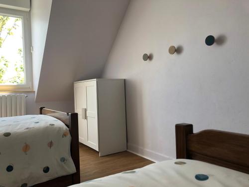 - une chambre avec 2 lits et une armoire blanche dans l'établissement Ty Albertine - Maison de campagne rénovée proche de la mer, à Plonévez-Porzay