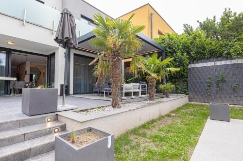 a house with palm trees in a courtyard at Luxury Vienna 6BR Villa with Private Pool & Sauna - Pets allowed in Vienna