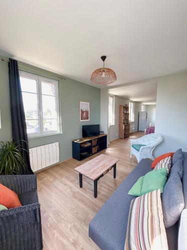 un salon avec un canapé et une table dans l'établissement Appartement 50 M de la mer, à Barneville-Carteret