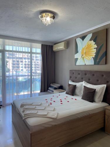 a bedroom with a large bed with red roses on it at Apart hotel Gallery L in Sunny Beach