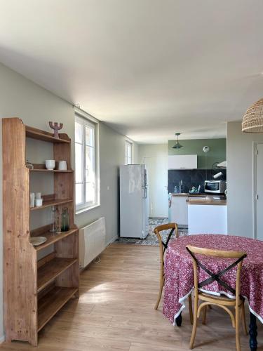 une cuisine et une salle à manger avec une table et un réfrigérateur dans l'établissement Appartement 50 M de la mer, à Barneville-Carteret