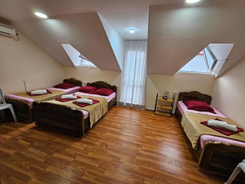 um quarto no sótão com 3 camas e uma janela em Imeri Hotel em Ureki