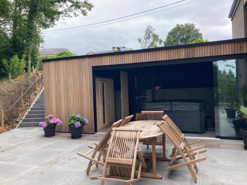 a patio with a table and chairs and a building at Gîte de la Tour in Hotton
