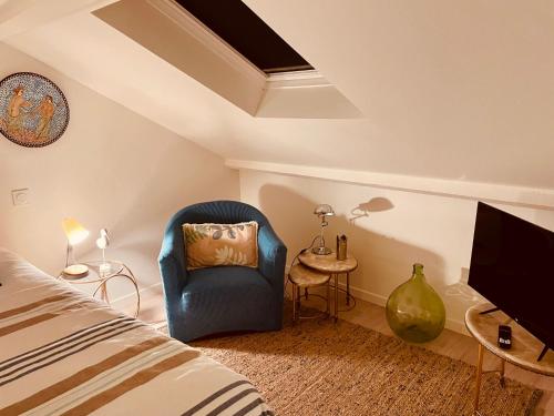 une chambre avec une chaise bleue et une télévision dans l'établissement Constance de Bretagne B&B, à Batz-sur-Mer