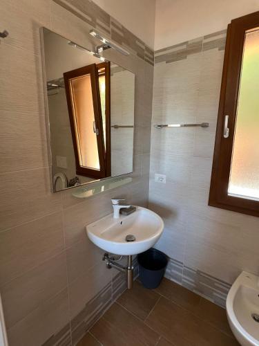 a bathroom with a sink and a mirror at Villetta Zuccale II Tranquillità e panorama vicino al mare in Capoliveri