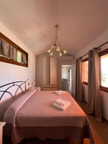 a bedroom with a bed and a chandelier at Villetta Zuccale II Tranquillità e panorama vicino al mare in Capoliveri