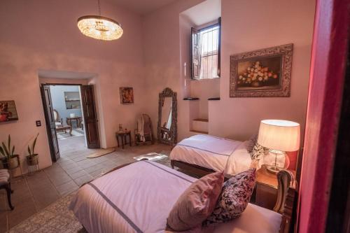 une chambre avec deux lits et un miroir dans l'établissement Hacienda con Alberca Vintage, à Ojo de Agua