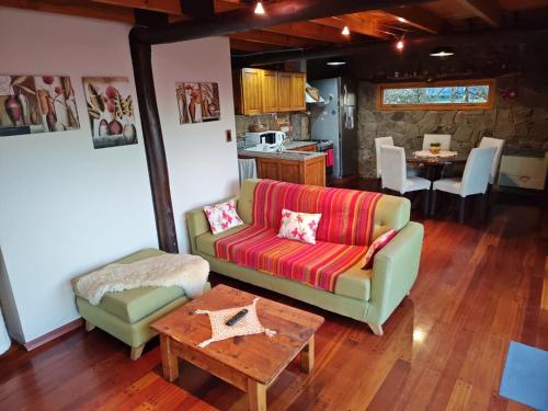 ein Wohnzimmer mit einem Sofa und einem Tisch in der Unterkunft Green House in El Calafate