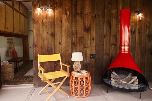 a room with a fireplace and a chair and a lamp at Catskills Retro Retreat- Upstate Home W Hot Tub in Saugerties