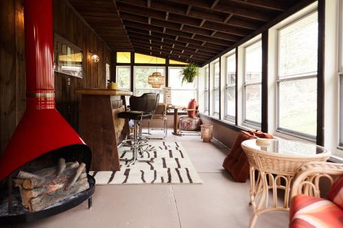a living room with a fireplace and a table and chairs at Catskills Retro Retreat- Upstate Home W Hot Tub in Saugerties