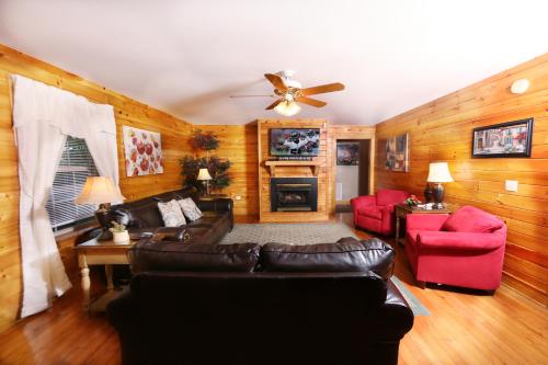 a living room with a leather couch and red chairs at Pinnacle View 7C by Eden Crest in Pigeon Forge