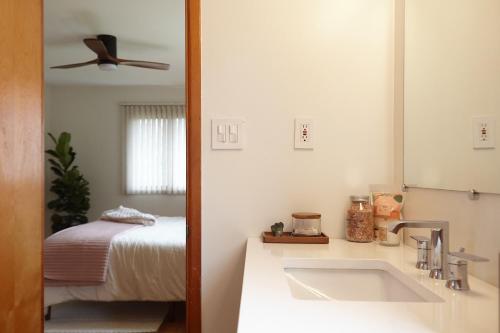 a bathroom with a sink and a bed and a mirror at Catskills Retro Retreat- Upstate Home W Hot Tub in Saugerties