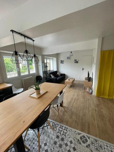 a living room with a wooden table and a living room at Appartement à 100m de la plage in Luc-sur-Mer